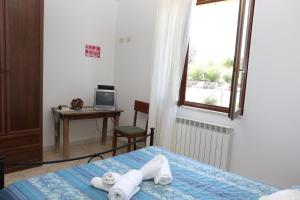 een slaapkamer met een bed, een tafel en een raam bij Agriturismo tinti in Montiano