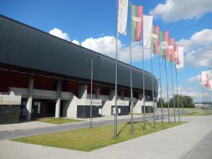 een rij vlaggen op palen voor een gebouw bij Apartament przy Stadionie in Tychy