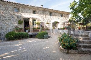 a stone house with a gate and stairs in front of it at Le Moulin de Beaunette in Grane