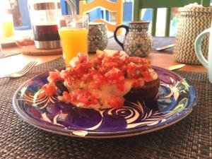 a plate of food on a table with a glass of orange juice at La Betulia Bed and Breakfast in Oaxaca City +12 photos