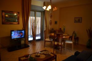 - un salon avec une télévision et une table à manger dans l'établissement Enzo's Homestay, à Gaggi