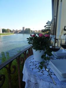 Casa Archi - Balcone sul Fiume في فيرونا: طاولة مطلة على النهر