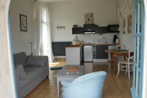 a living room with a couch and a kitchen at La Bleuette in Montmaur