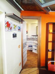 an orange bathroom with a toilet and a door at Nolo Loft in Milan in Milan
