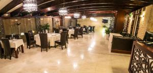 a dining room with tables and chairs and chandeliers at Hotel Aramia in Satu Mare