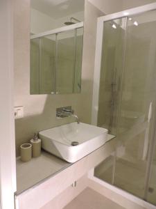 une salle de bain avec un lavabo et une douche en verre dans l'établissement san cosimato suite, à Rome