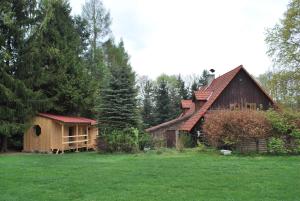 a large wooden house in a field with trees at Adršpach U Meierů in Adršpach