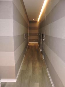 un corridoio con pareti a strisce e pavimento in legno di san cosimato suite a Roma