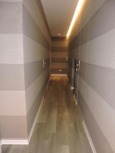 un couloir avec des murs rayés et un plancher en bois dans l'établissement san cosimato suite, à Rome 1 autre photo