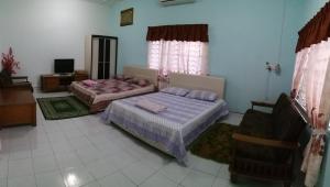 um quarto com duas camas e uma televisão em Dhia Irdina Homestay em Paya Rewak
