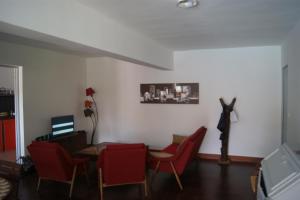 a living room with red chairs and a table at Villa Aquarêve in Saly Portudal