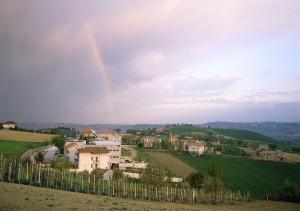 a rainbow in the sky over a village on a hill at Casa Claudia in Montecassiano