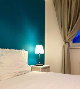ein Schlafzimmer mit einem weißen Bett und einer blauen Wand in der Unterkunft AVA Apartments ADORA FOREST 1 in Timişoara