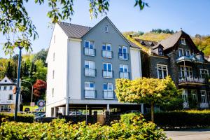 a large white building with blue windows at aparthotel Cochem in Cochem