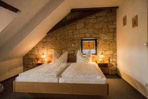 a bedroom with a large bed in a stone wall at Hotel Zum Klosterfischer in Blankenburg