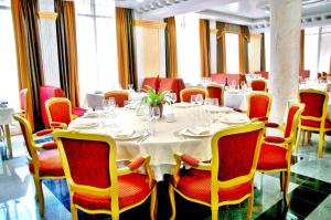 a dining room with a white table and red chairs at Actor Hotel Budapest in Budapest