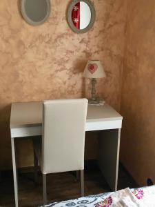 einen weißen Schreibtisch mit einem Stuhl und einer Lampe in der Unterkunft La Maison de Pagan Alloggio ad uso turistico VDA CHARVENSOD n 0021 in Aosta