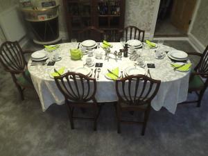 a dining room table with a white table cloth and chairs at Dol Llan Mansion in Llandysul