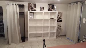 a white shelf with pictures on it in a room at Au Mariafeld in Houssen
