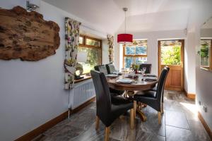a dining room with a wooden table and black chairs at Invermay in Blairgowrie