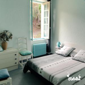 um quarto com uma cama, uma cadeira e uma janela em Domaine Saint Andrieu em Greffeil
