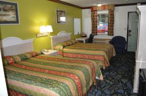 two beds in a hotel room with green walls at Economy Inn Cuyahoga Falls in Cuyahoga Falls