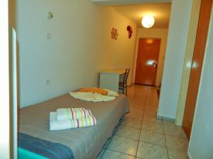 um quarto com uma cama com duas toalhas em Τripoli-Αpartments-Rooms-Stay em Trípoli
