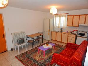 a living room with a red couch and a kitchen at Τripoli-Αpartments-Rooms-Stay in Tripoli