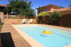 a swimming pool with a raft in the water at Maison Addama in Neyron
