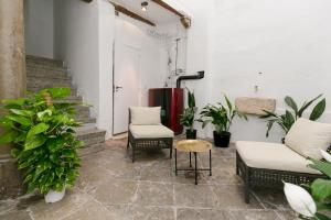 un patio con sillas, mesa y plantas en HOSPEDAJE PENSIÓN LA ALMOHADA, en Granada