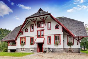 托特莫斯拉昆塔酒店 - 仅限成年人的前面有一辆自行车,是一座红色和白色的大房子