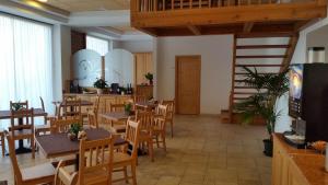 a restaurant with wooden tables and chairs and a staircase at Agritur Maso Barco in Faedo