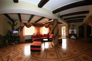 a living room with a couch and a tv at Pensiunea Ianis Moieciu in Moieciu de Jos