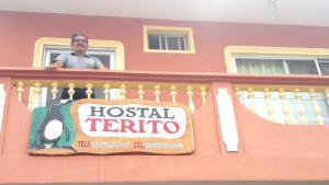 a man standing on a balcony of a hotel keritus at Hostal Terito in Puerto Baquerizo Moreno
