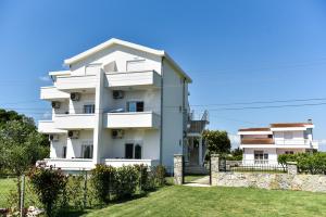 a white house with a fence in front of it at Sunrise house apartments in Ulcinj