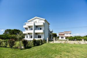 a white house with a yard in front of it at Sunrise house apartments in Ulcinj