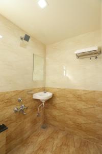 a bathroom with a sink and a mirror at Hotel Loyal Residency in Jamnagar