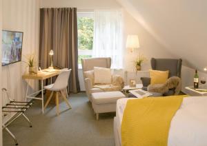Schlafzimmer mit einem Bett, einem Schreibtisch und Stühlen in der Unterkunft Hotel Auszeit in Isernhagen