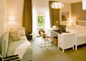 a bedroom with a bed and a desk with a laptop at Hotel Auszeit in Isernhagen