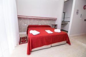 a room with a red table with two towels on it at Colores Rio Cuarto in Río Cuarto