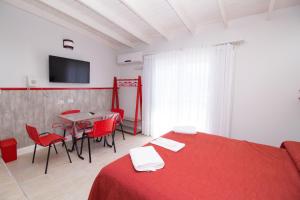 a room with a red bed and a table and chairs at Colores Rio Cuarto in Río Cuarto +85 photos