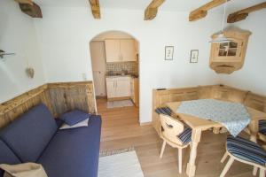ein Wohnzimmer mit einem blauen Sofa und einem Tisch in der Unterkunft Mutznhof in Toblach