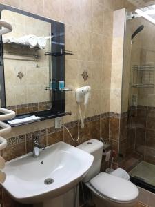 a bathroom with a sink and a toilet and a shower at Gostinitsa Grand in Qyzylorda +26 photos