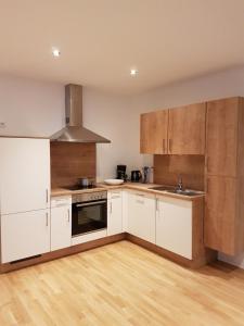 a kitchen with white appliances and wooden cabinets at Ferienwohnung Jolina in Lustenau