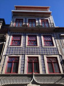 un edificio alto con ventanas rojas y azules. en Loft Mártires, en Oporto