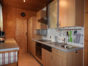 a kitchen with wooden cabinets and a sink at Landhaus Rasser in Rauris