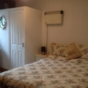 a bedroom with a bed and a lamp on the wall at Divine Mercy B&B in Knock