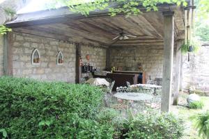 un patio con mesa, sillas y pared de piedra. en Jailer's Inn en Bardstown