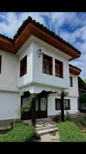 Una gran casa blanca con ventanas en la parte superior. en Bujtina Zhaveli, en Gjakove