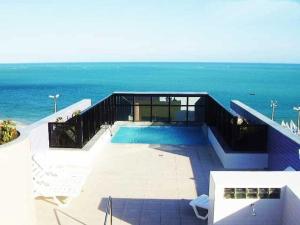 una piscina con el océano al fondo en Edifício NEO 1, en Maceió